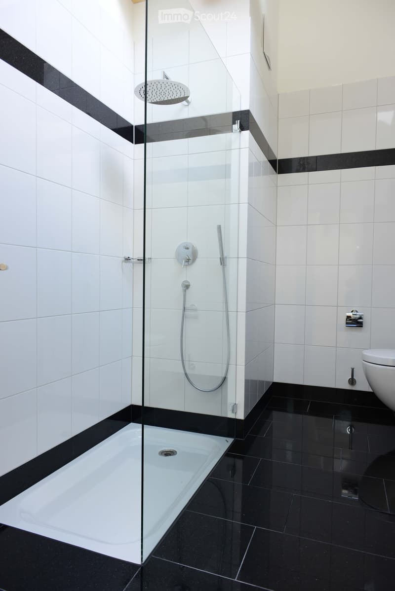white tiles, glass shower, chrome fixtures, drain, shower head, toilet