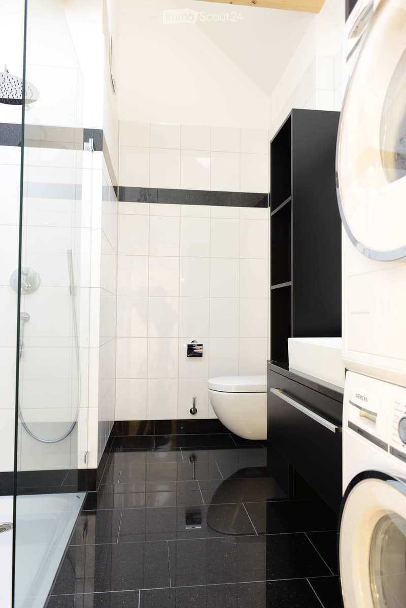 modern bathroom with shower, white toilet, washing machine, sink, tiled floor