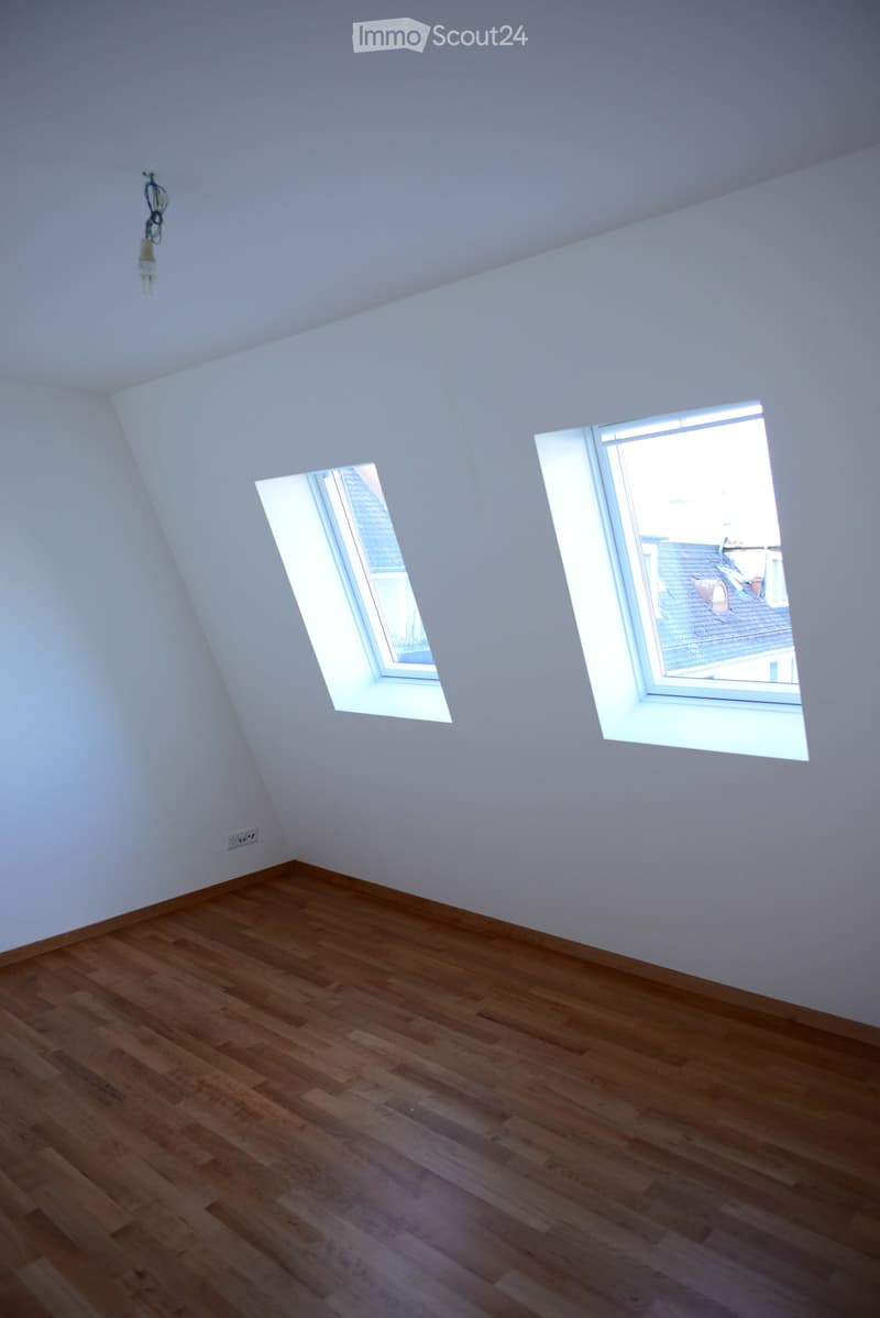 empty room, wooden floor, white walls, two windows, slanted ceiling
