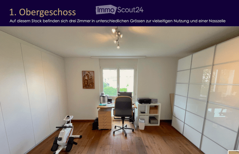 Office space with wooden flooring, large window, desk with chair, printer, cabinet, and exercise bike.