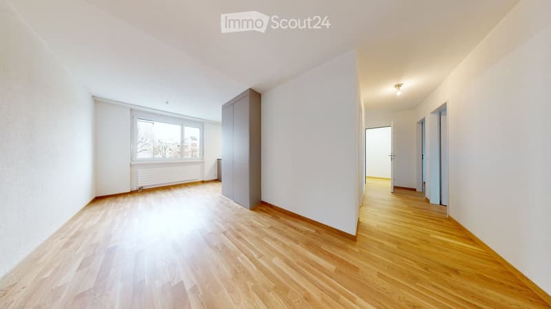 Empty room with wooden flooring, white walls, and a large window. No furniture or equipment is present.