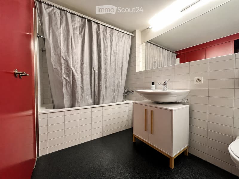 Modern bathroom with white tiles, a bathtub, a sink with a faucet, a mirrored cabinet, and a shower curtain.