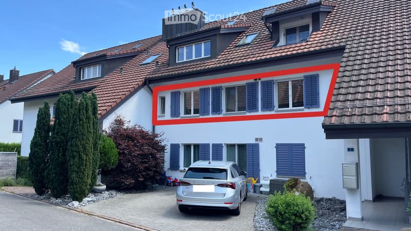 Two-story house with red-tiled roof, white walls, blue shutters, and multiple windows. A silver car is parked in the driveway.