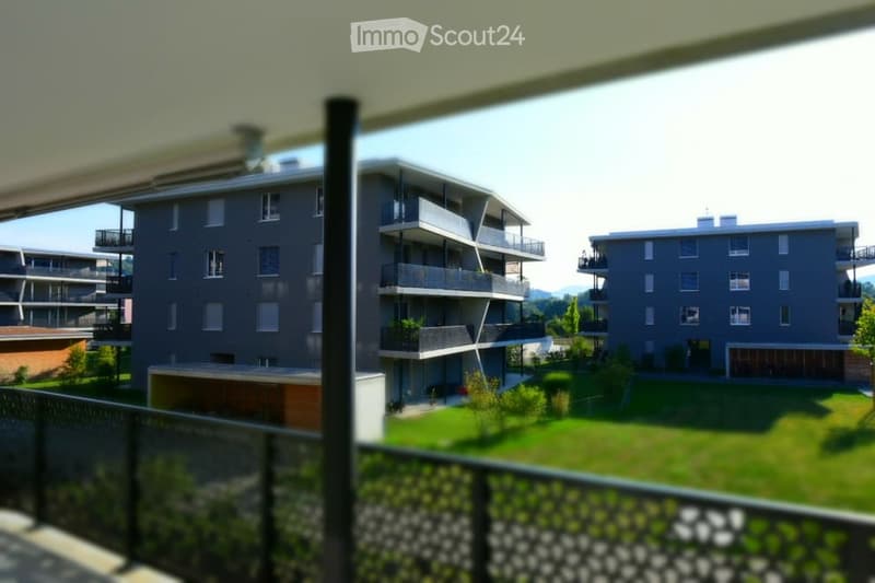 residential apartment buildings with balconies and green lawns in between