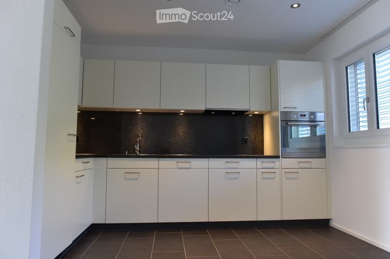 modern kitchen with white cabinets, tiled floor, stainless steel appliances, large sink with faucet