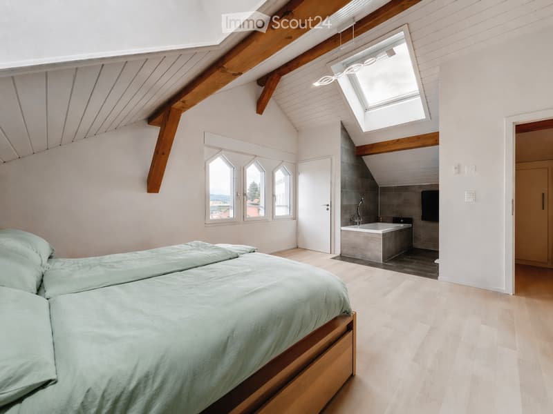 bedroom with wooden beams, wooden floor, bed, bathtub, skylight