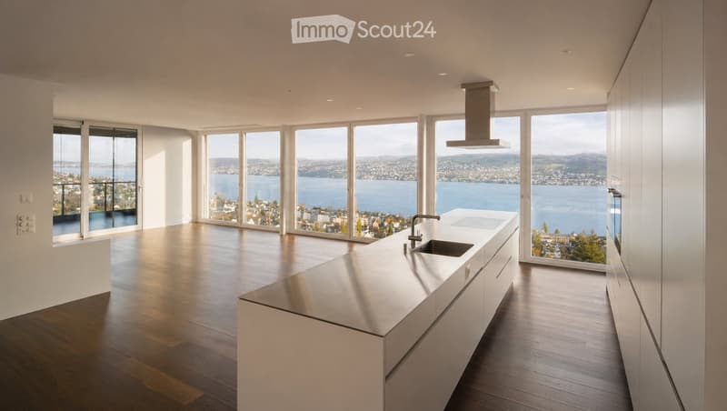 Kitchen. Modern kitchen with white cabinets, stainless steel island, large windows offering a scenic view of a lake and cityscape.
