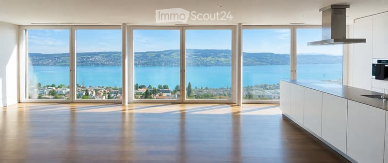 Kitchen. Modern kitchen with large windows offering a scenic lake view, white cabinetry, and a central island.