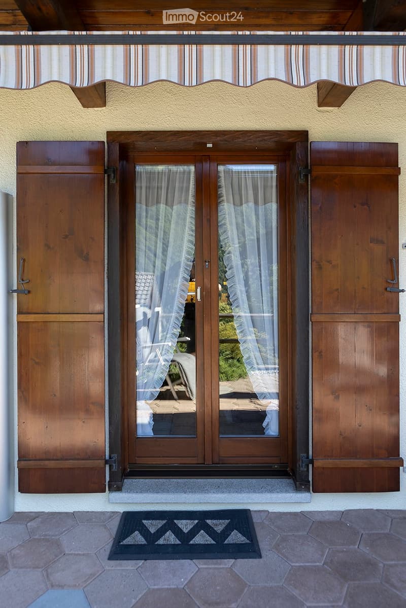 Exterior entrance, wooden double doors, striped awning, wooden shutters, hexagonal stone flooring