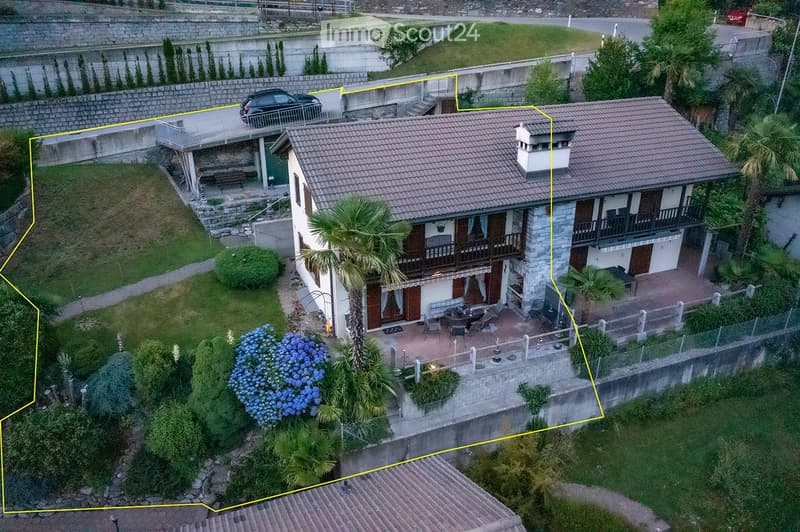 House: brown roof, white and brown walls, glass windows, chimney, terrace, outdoor dining table, car parked in front