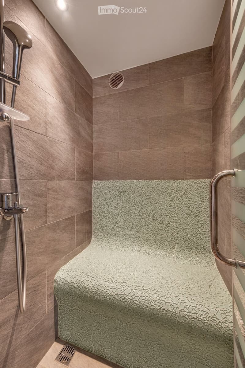 Bathroom. Modern bathroom with a sleek shower area, featuring a textured green mosaic tile seat and a stainless steel showerhead with handheld sprayer.
