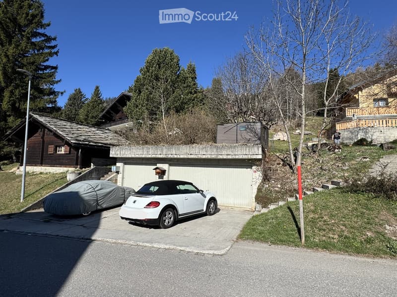 Two-story house with a garage, white convertible car parked in front, and a covered car to the left.