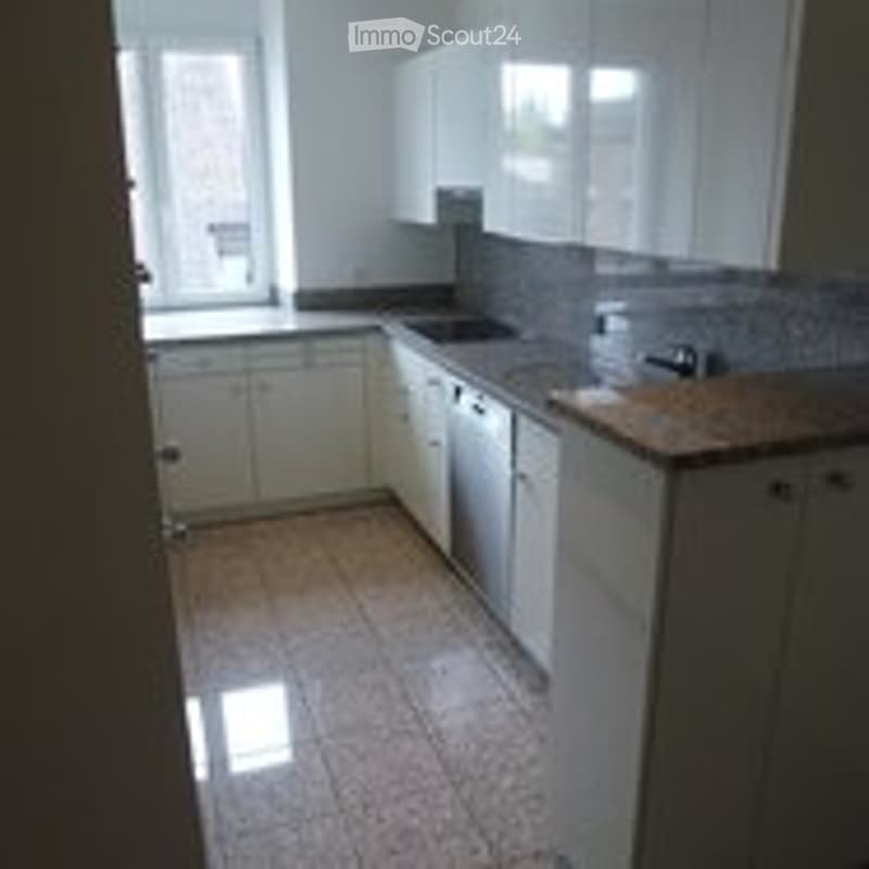 Bright, modern kitchen with white cabinets, a sink, a dishwasher, and a tiled floor.