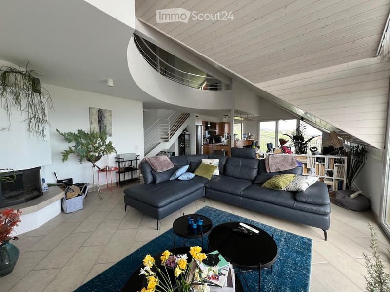 Modern living room with a large sectional sofa, coffee tables, fireplace, bookshelf, and decorative plants.