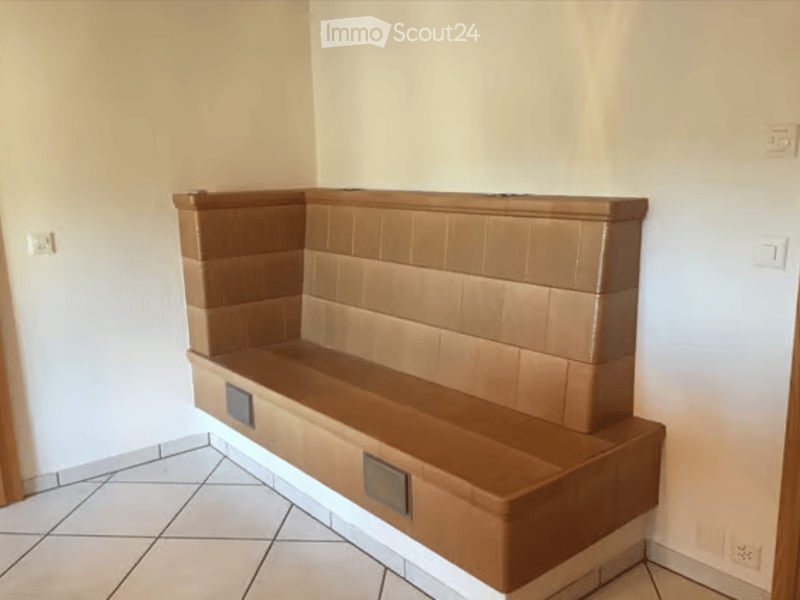 Empty room with a built-in bench along one wall, tiled floor, and white walls.
