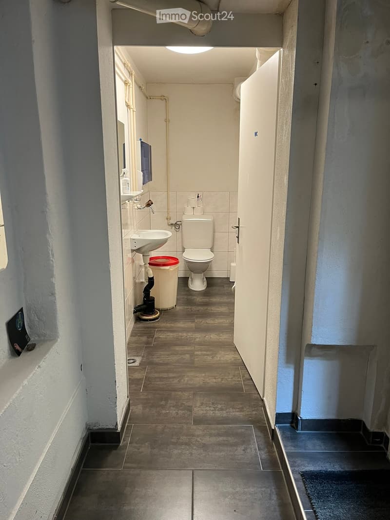 Bathroom: sink, toilet, trash bin, floor drain, tiled floor