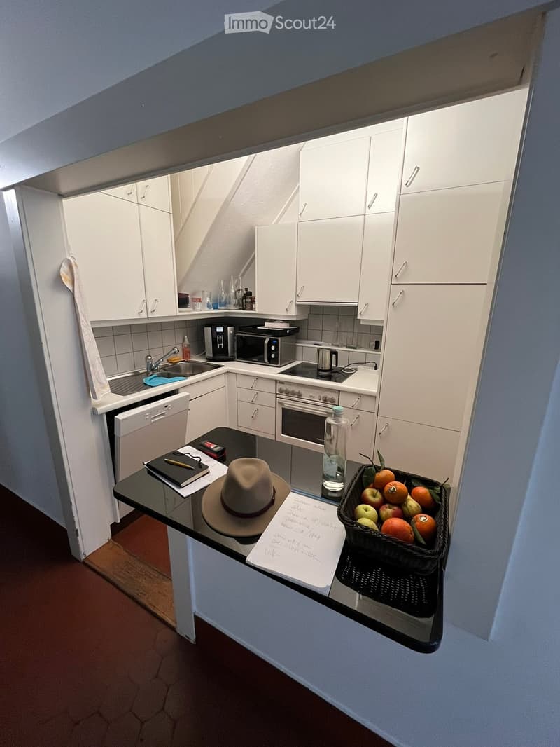 open plan kitchen with countertops, dishwasher, white cabinetry, sink, oven, dishwasher, black countertop, basket of fruit, modern appliances