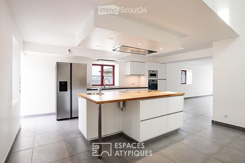 Modern kitchen with white cabinets, stainless steel appliances, and a central island with wooden countertop.