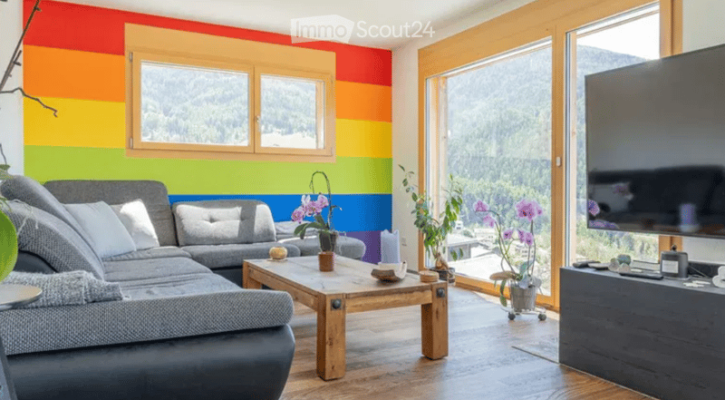 two sofas, coffee table, TV, plants, wooden floor, colorful walls, large windows