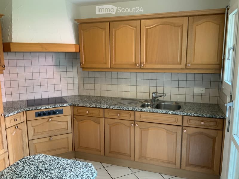 Kitchen with granite countertops, wooden cabinets, sink, and oven.