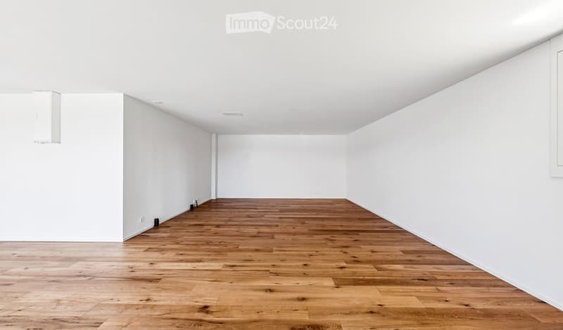 Empty room with white walls and wooden flooring, no furniture or equipment.
