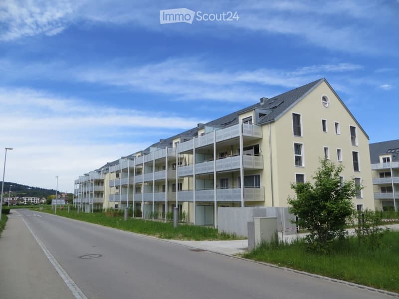 Modern multi-story apartment building with balconies and a clean, contemporary design.