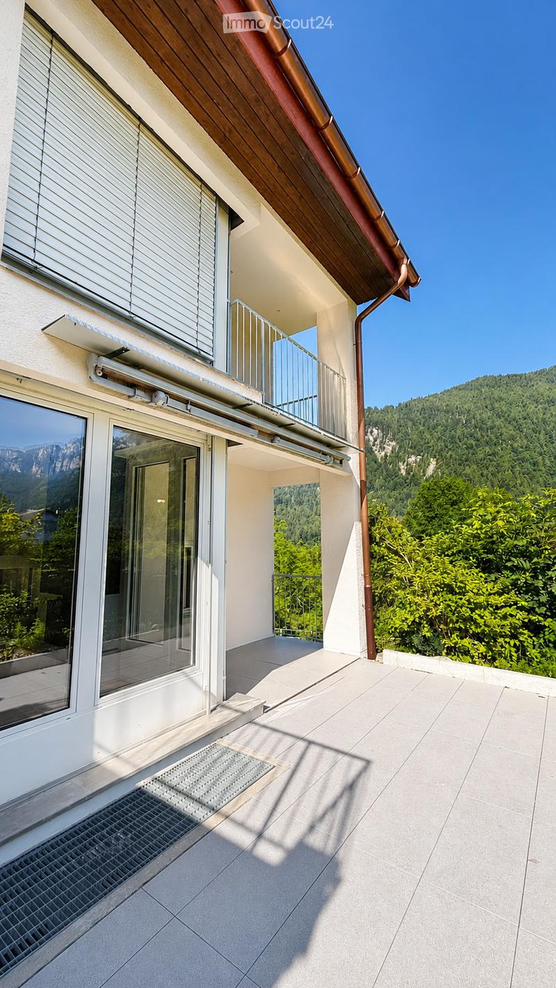 Balcony with modern design, large windows, metal railings, and scenic mountain view.