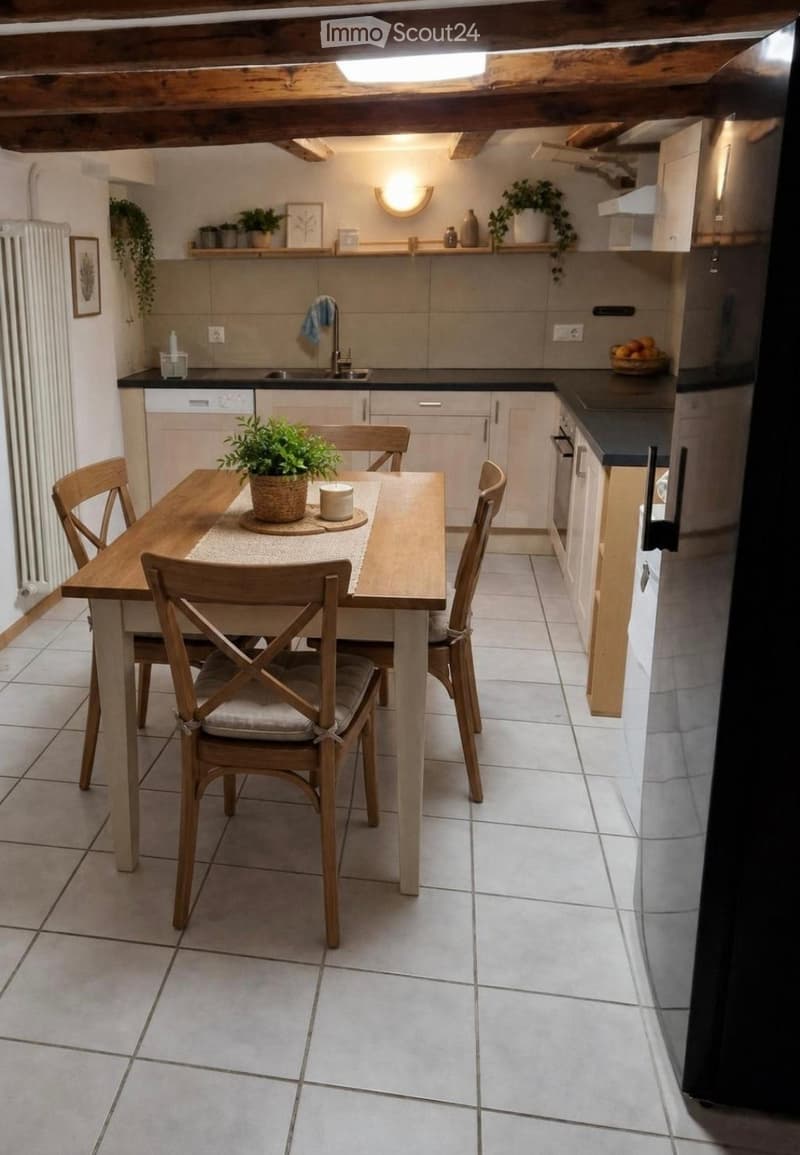 Cozy kitchen with a wooden dining table and four chairs, white tiled floor, modern cabinets, and a sink with a faucet. Shelves hold decorative items and plants.