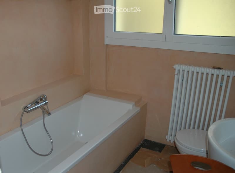 white bathtub, white sink, white toilet, white radiator, beige walls