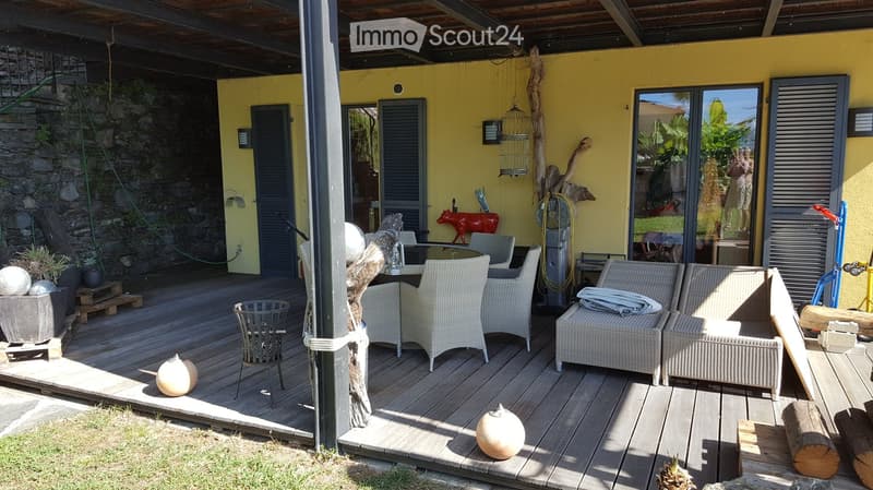 outdoor dining area, wicker chairs, round table, yellow painted wall, gray shutters, white wicker lounge chairs