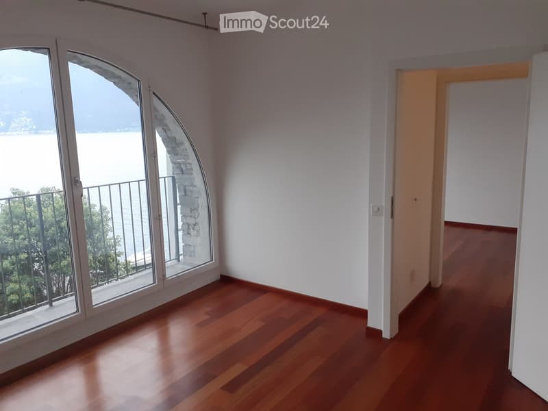 Empty room, wooden floor, large windows, balcony, view of the sea