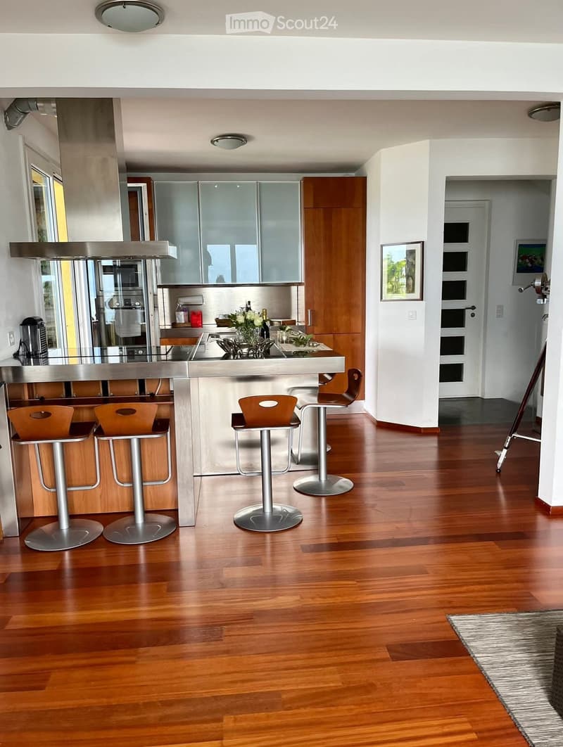 modern kitchen with wooden floors, stainless steel island, wooden cabinets, appliances, kitchenware