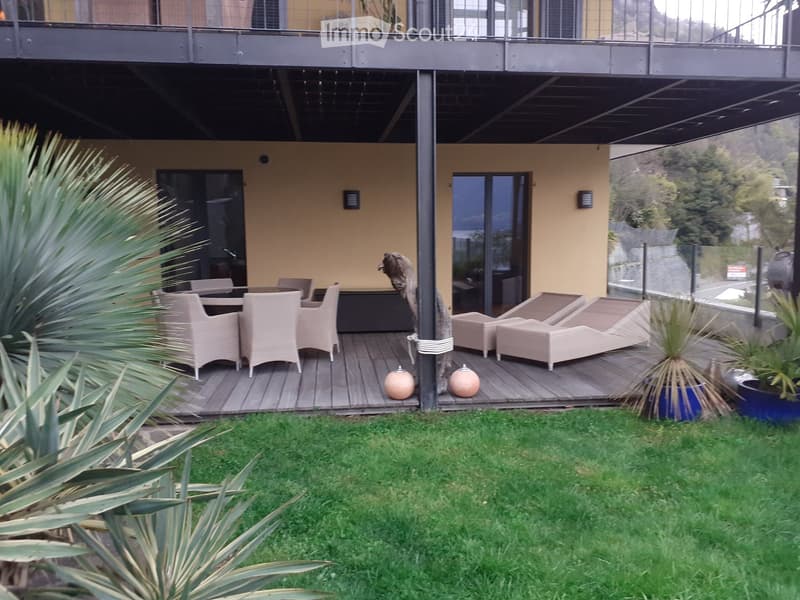 Terraced house with wooden deck, modern furnishings, yellow walls, metal railings, elevated position, distant mountain view