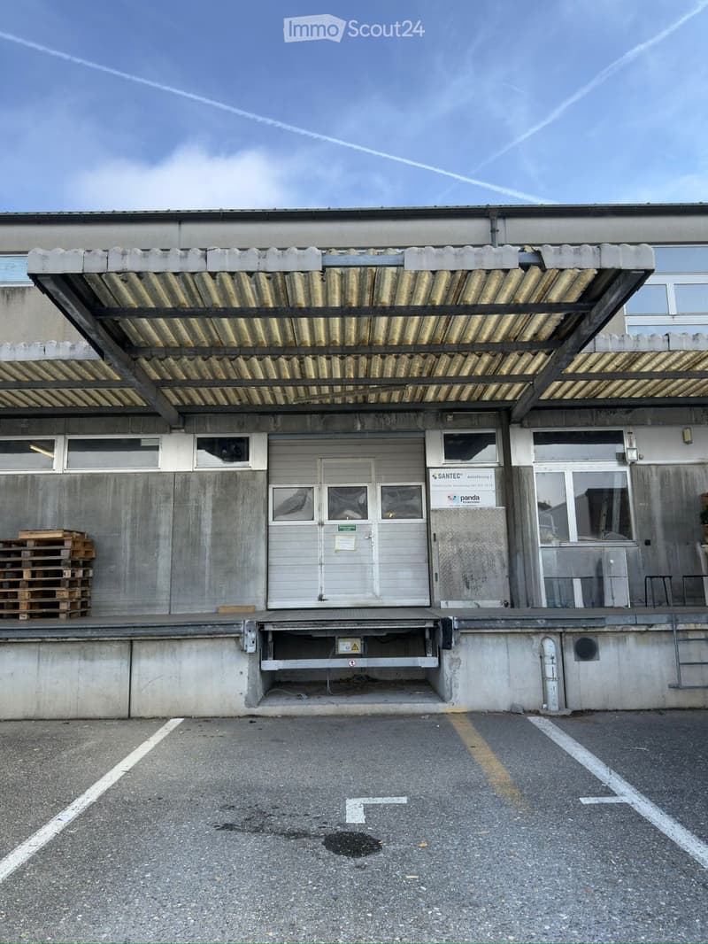 industrial building, loading dock, sign reading 'Panda', parking lot