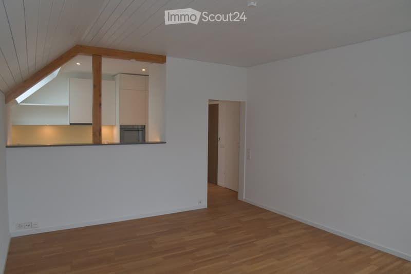 empty room, wooden floor, white walls, kitchen area, wooden beams