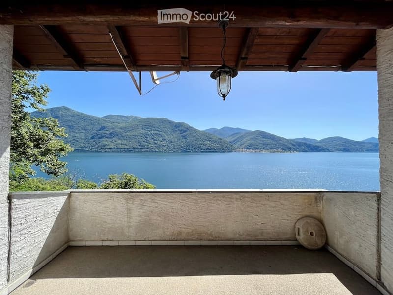 outdoor balcony with ceiling, overlooking large lake and mountains