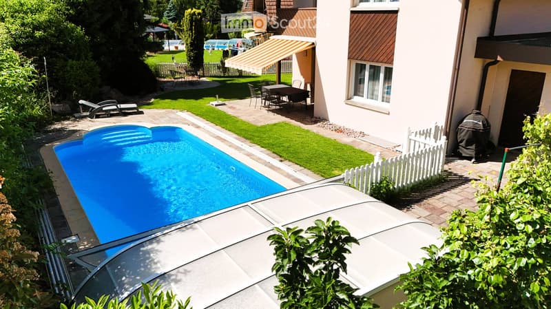 Private garden with a swimming pool, lounge chairs, outdoor dining set, and surrounding greenery.