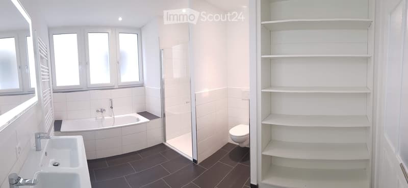 Bathroom with bathtub, shower, toilet, sink, shelves, and windows