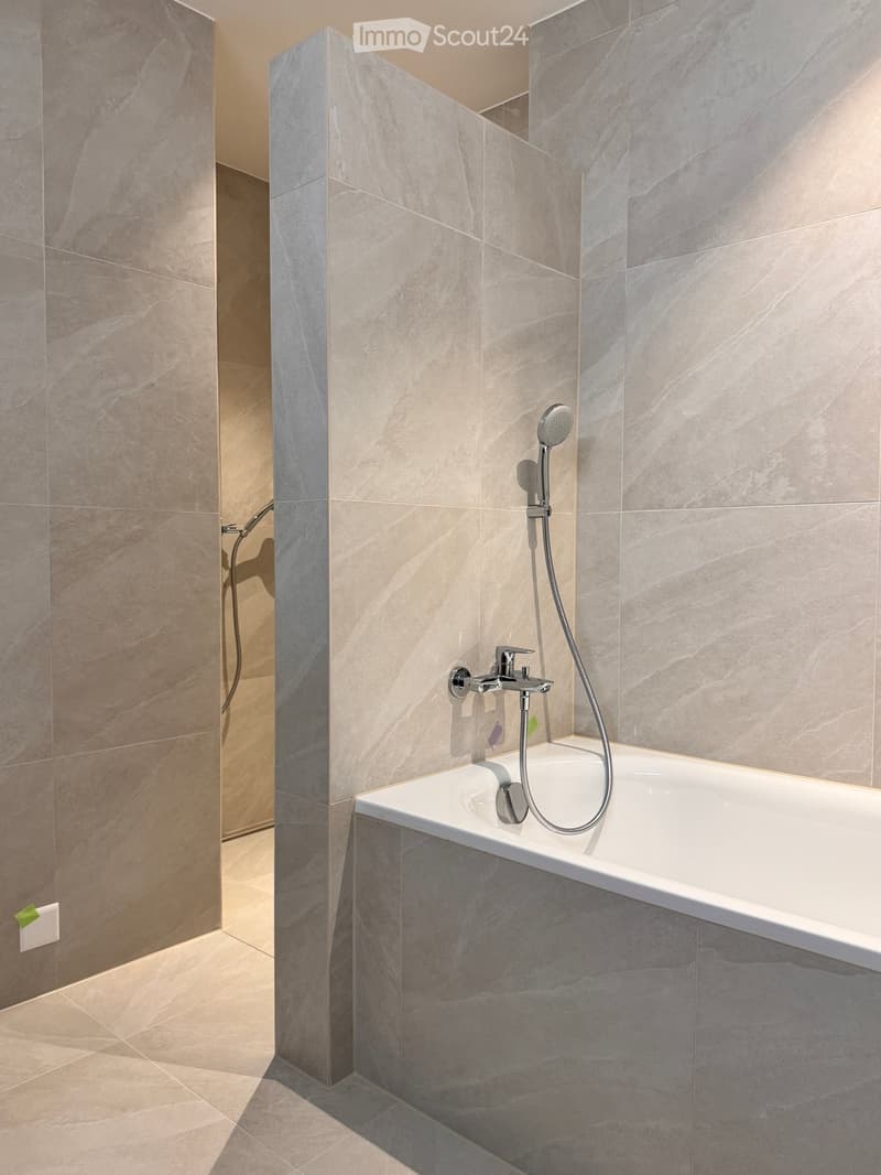 Bathroom. Bathroom with marble tiles, bathtub, and shower fixtures.