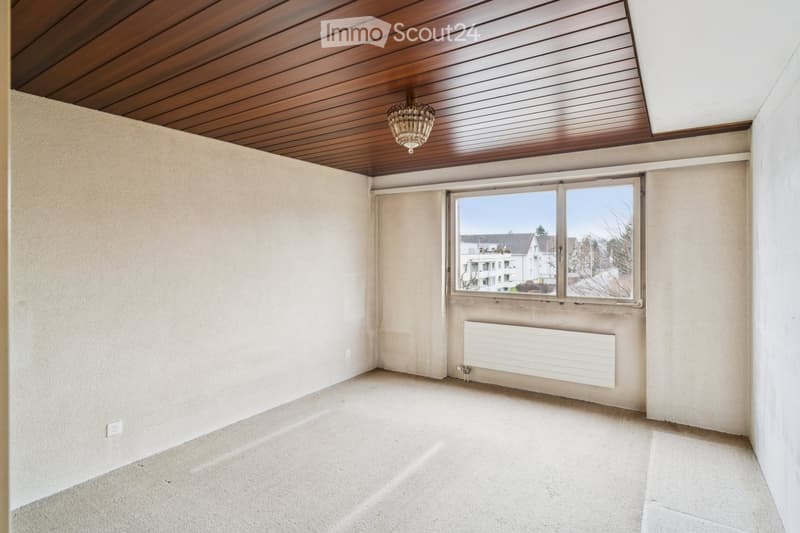 empty room with wooden ceiling, radiator, power outlet, window