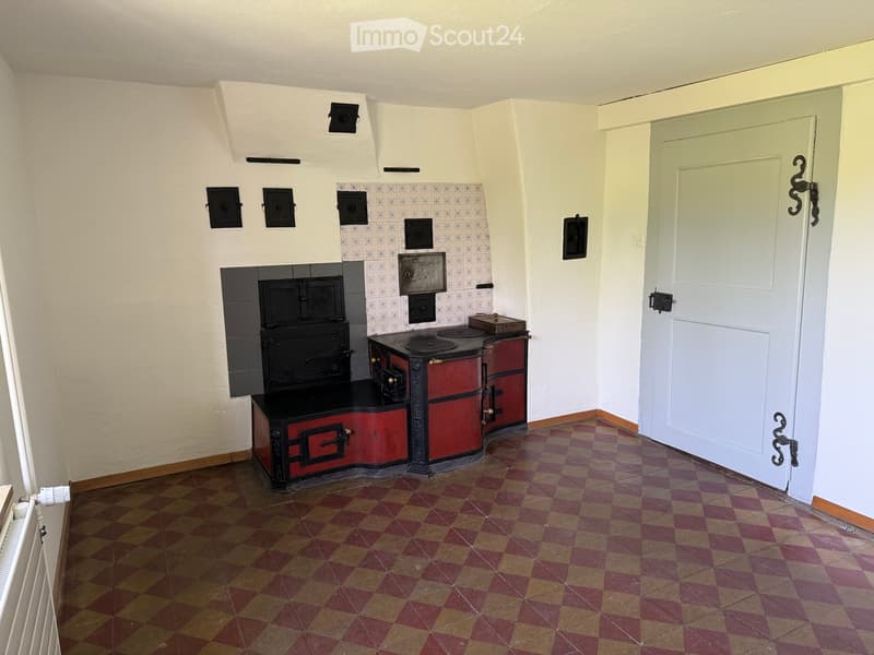 Kitchen. A vintage kitchen with a red and black stove, a black oven, and checkered flooring.