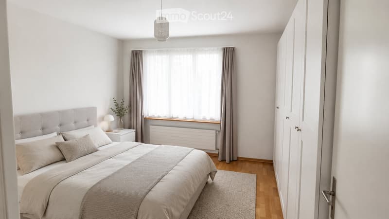 Modern bedroom with a large bed, nightstand, lamp, vase with plants, and a window with curtains. Wooden flooring and a rug are also visible.