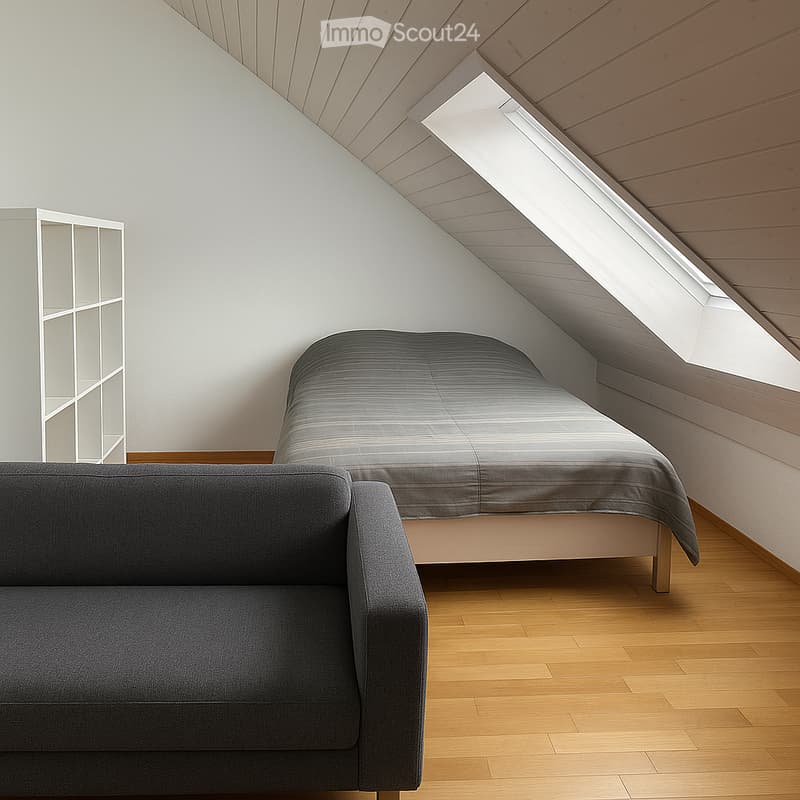 Modern attic bedroom with wooden slanted ceiling, skylight window, grey sofa, bed with grey duvet, and white shelving unit.
