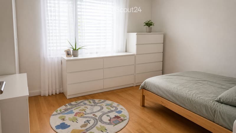 A tidy bedroom with a wooden bed, nightstand, potted plant, picture frame, and a colorful rug on the floor.