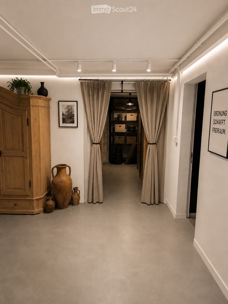 A well-lit hallway with beige carpeting, white walls, and modern lighting. Features include a wooden cabinet with decorative vases, framed artwork, and a curtained doorway leading to another room.