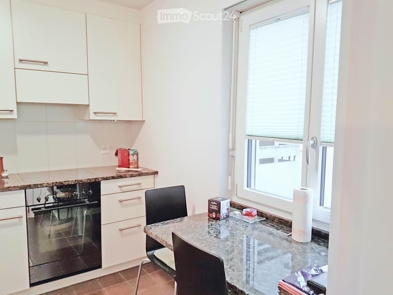 modern kitchen with white cabinets, granite countertops, built-in oven, window with blinds, dining table with chairs