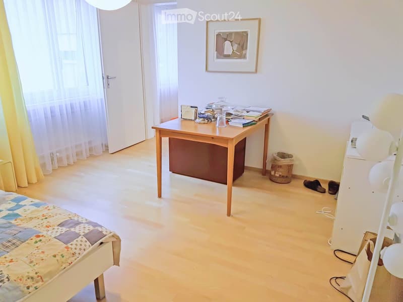 bedroom with bed, desk, trash bin, picture frame, lamps, shoes, curtains
