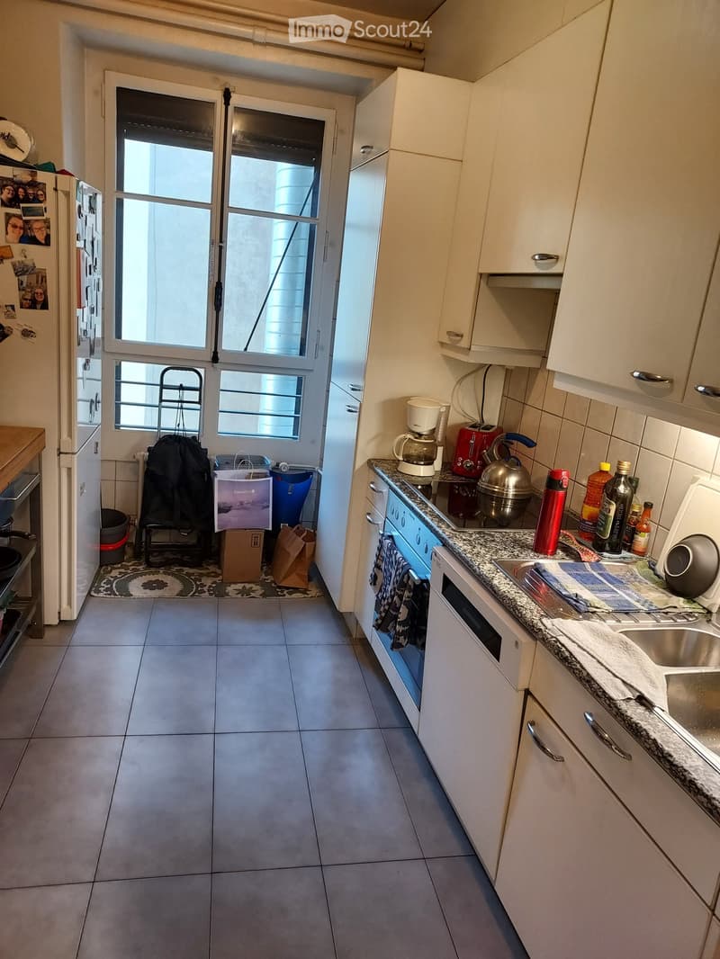 Modern kitchen with white cabinets, granite countertop, stainless steel appliances, and a windowed door leading to a balcony.