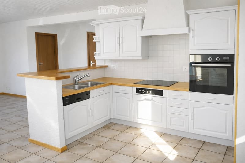 Modern kitchen with white cabinets, wooden countertops, stainless steel sink, and built-in appliances including an oven, dishwasher, and stove.