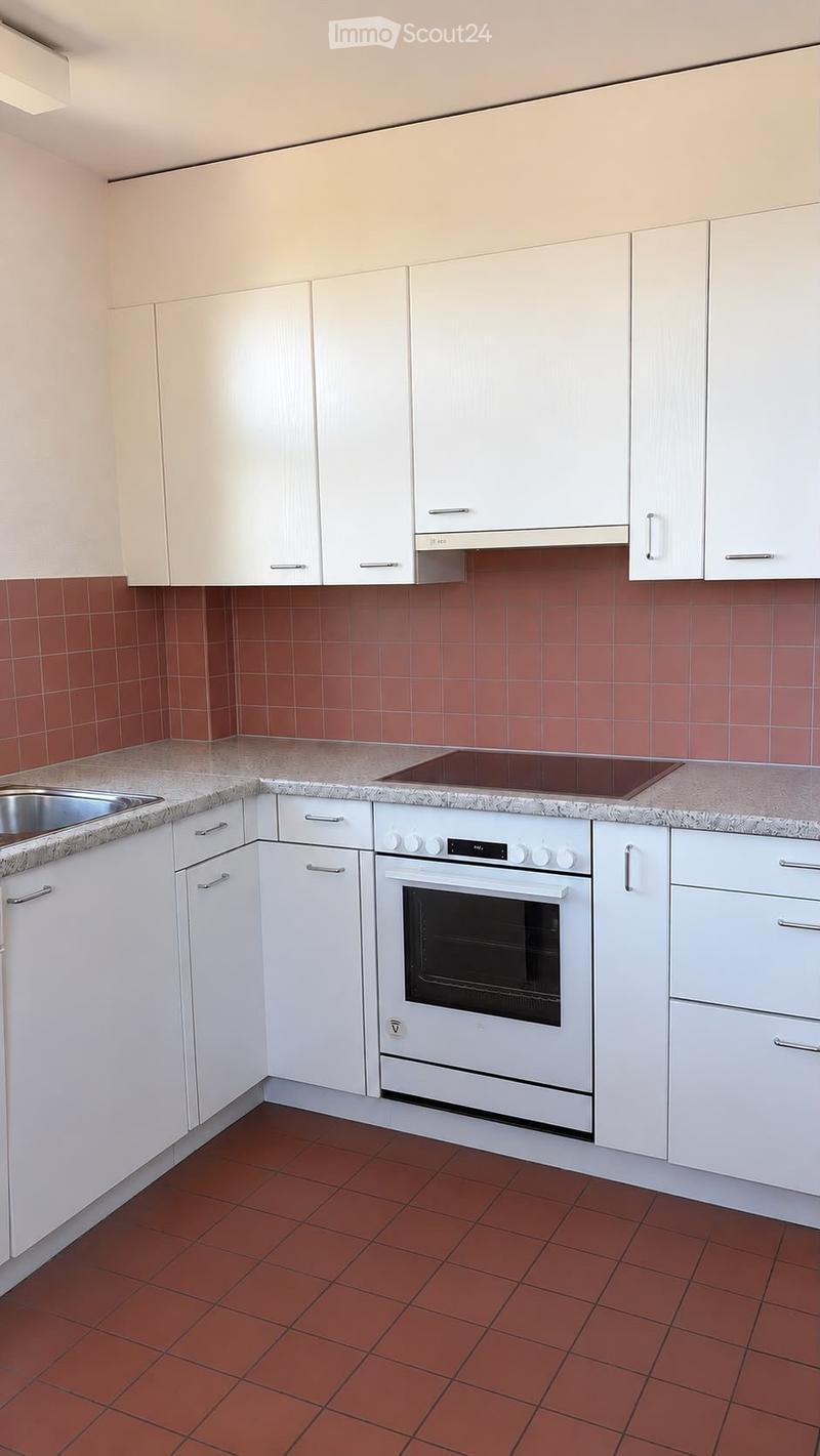 Modern kitchen with white cabinets, granite countertops, red tiled backsplash, and a built-in oven.